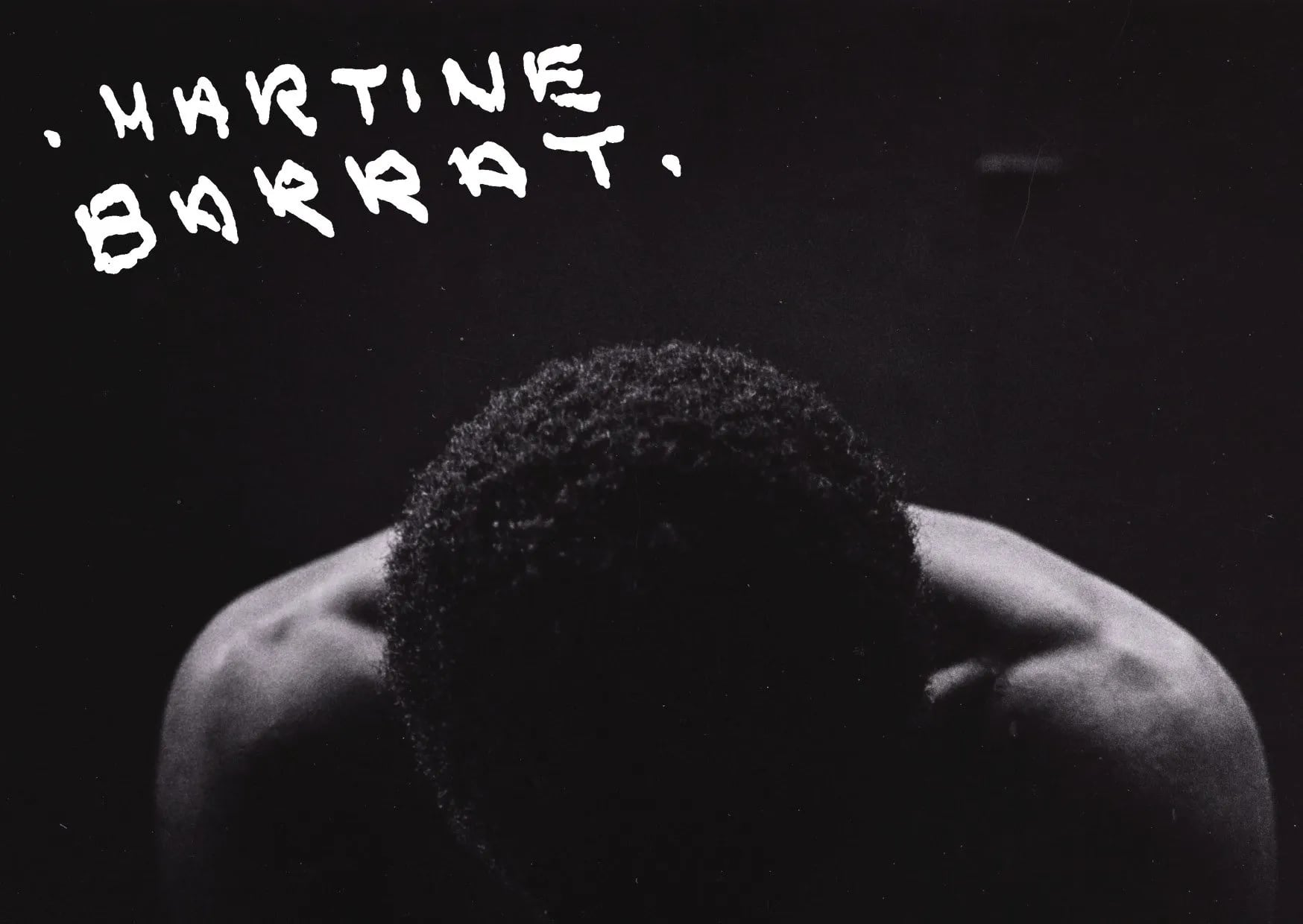 Black and white postcard: a person's bowed head and shoulders in the dark, with handwritten white "Martine Barrat"