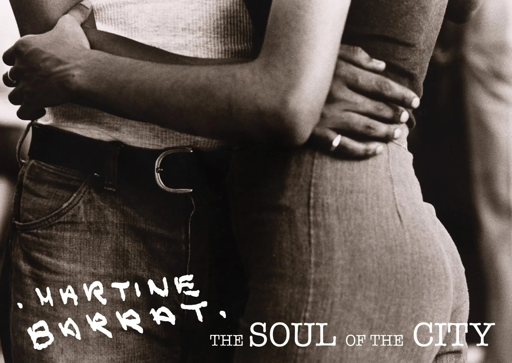 Sepia close crop of two people embracing at the waist in jeans, with "Martine Barrat" handwritten and "The Soul of the City"