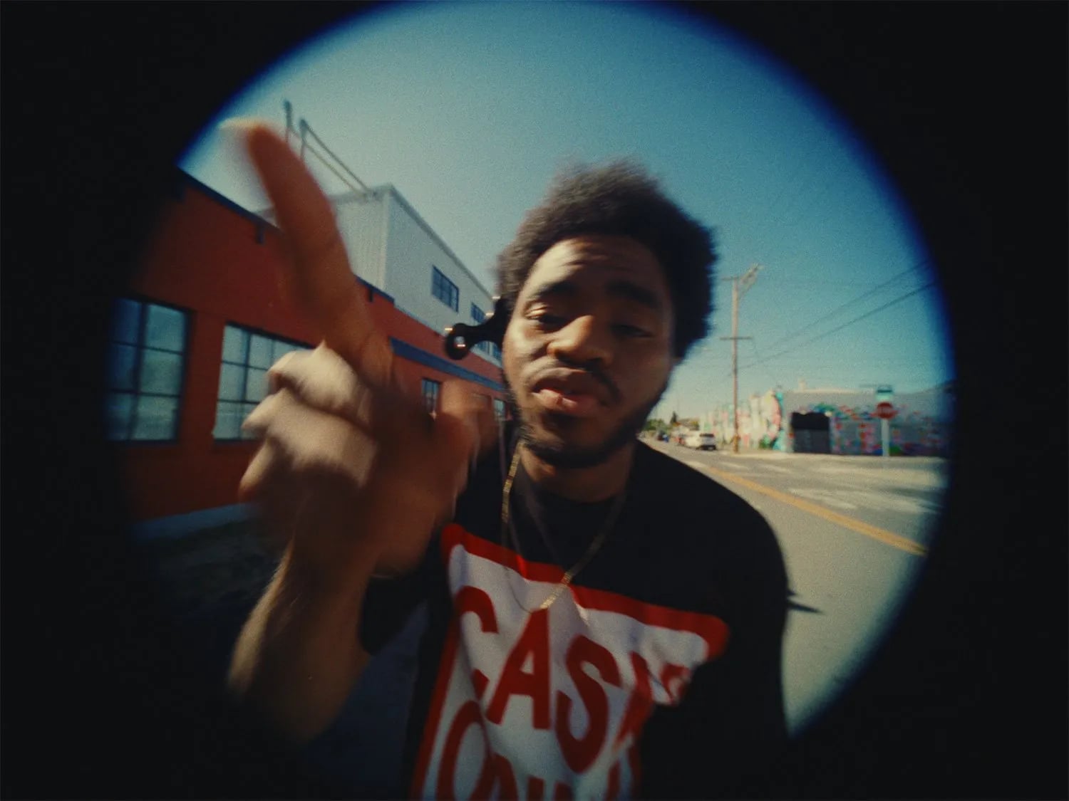 Fisheye frame from the Bipper's Joint music video: a man in a CASH ONLY tee pointing at the lens, shown in a round vignette