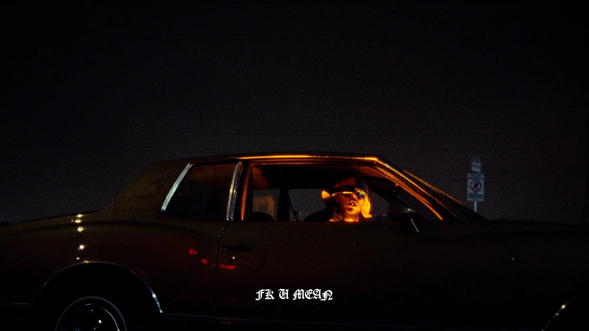 Frame from the Pink Siifu Fk U Mean / Hold Me Dwn video: person in a parked car at night, title "FK U MEAN" lyric subtitle below