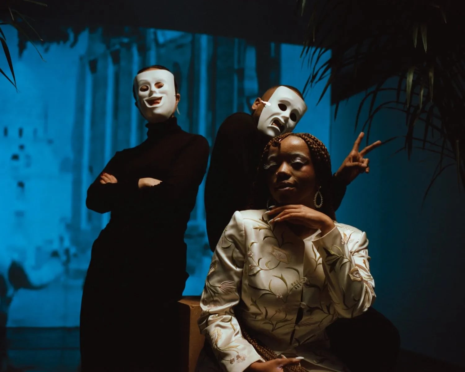 Frame from the Stoney Creation Repair video: a seated woman in a patterned jacket with two people in white masks behind her